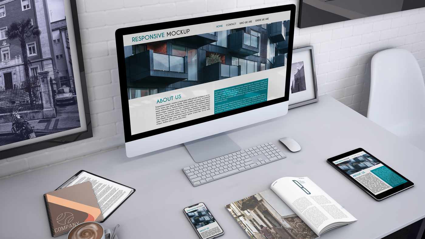 Abogado con traje revisando su web profesional en MacBook en despacho elegante con libros jurídicos al fondo