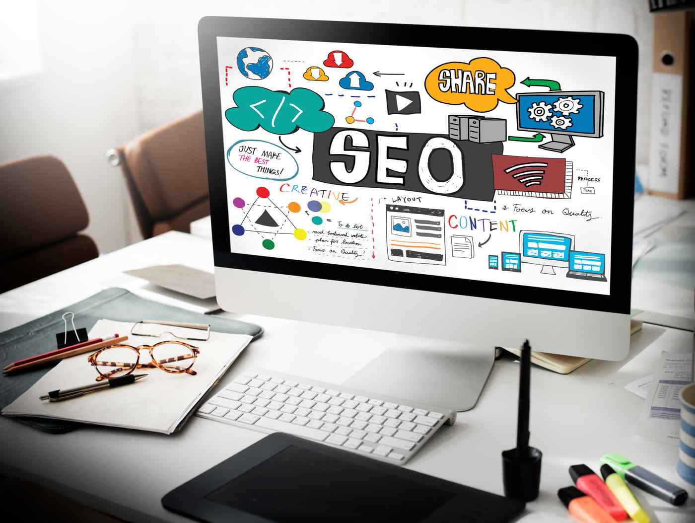 Desarrollador trabajando en SEO técnico web con doble monitor y teclado mecánico en oficina con luz cálida